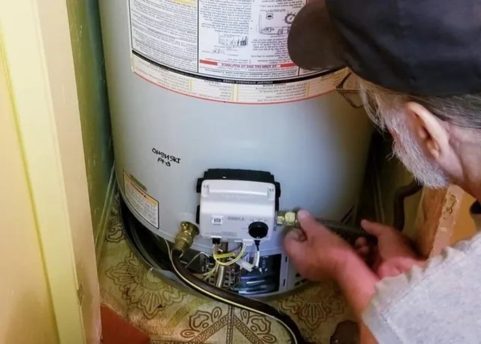 Licensed plumbing technician inspecting a residential water heater